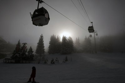 Overhead cable car on snow covered field