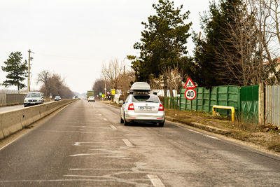 Cars on road against sky in city