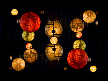 Illuminated lanterns hanging against black background
