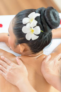 Cropped hands of therapist massaging woman back at health spa