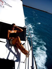 Woman sitting on boat in sea against sky