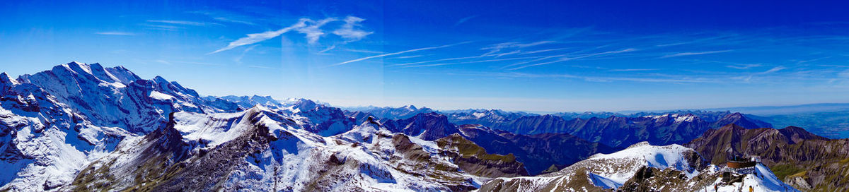 Panoramic view of snowcapped mountains against blue sky