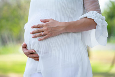 Midsection of couple holding hands