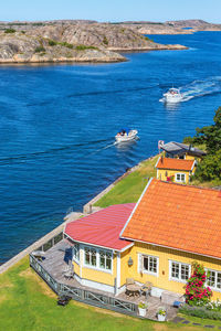 High angle view of houses by sea against sky