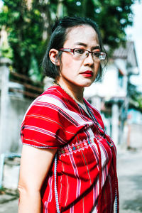 Portrait of beautiful woman standing against red shirt. 