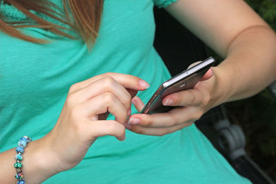 Midsection of woman holding mobile phone