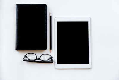 Close-up of eyeglasses on table against white background