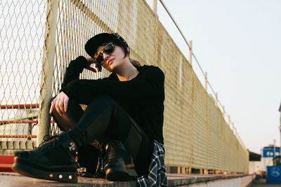 Side view of young woman looking through window. fence.construction net. korean fashion. european.