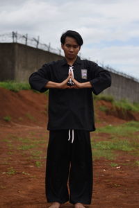 Young man practicing karate on field