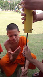 Boy holding camera on field