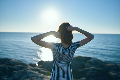 Woman standing in sea against sky