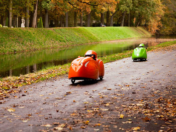 Rear view of man cycling on footpath during autumn