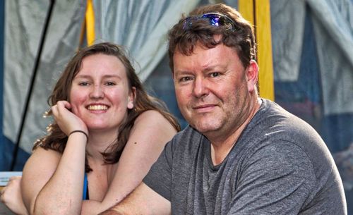 Portrait of smiling father and daughter sitting at cafe