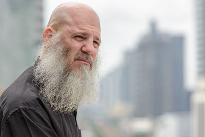 Close-up of man with beard looking away outdoors