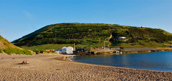 Scenic view of beach against clear blue sky