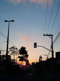 Cars on road against sky during sunset