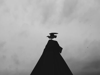 Low angle view of silhouette statue against sky