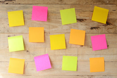 Close-up of colorful blank adhesive notes on wooden wall