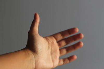 Close-up of human hand against gray background