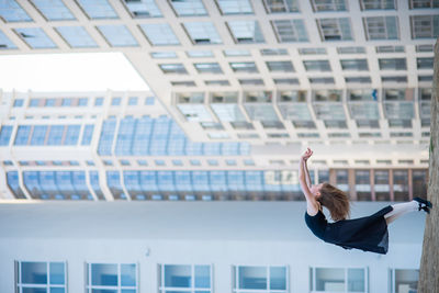 Low angle view of woman on building in city