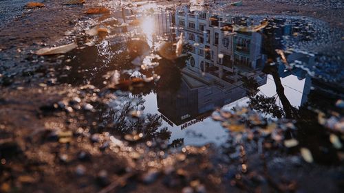 Reflection of buildings in puddle on street