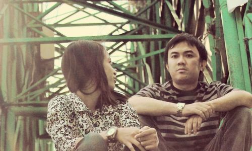 Portrait of young couple sitting outdoors