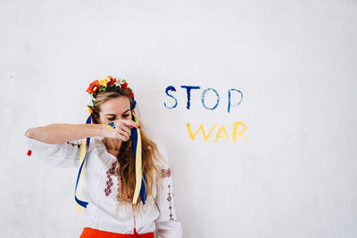 Woman wearing tiara against wall