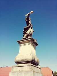 Low angle view of statue against clear blue sky