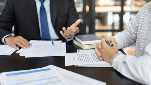 Midsection of business people working on table