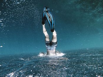 Low section of man swimming in sea