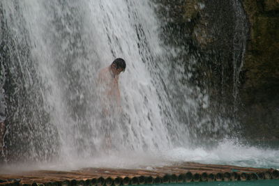 View of person standing in waterfall