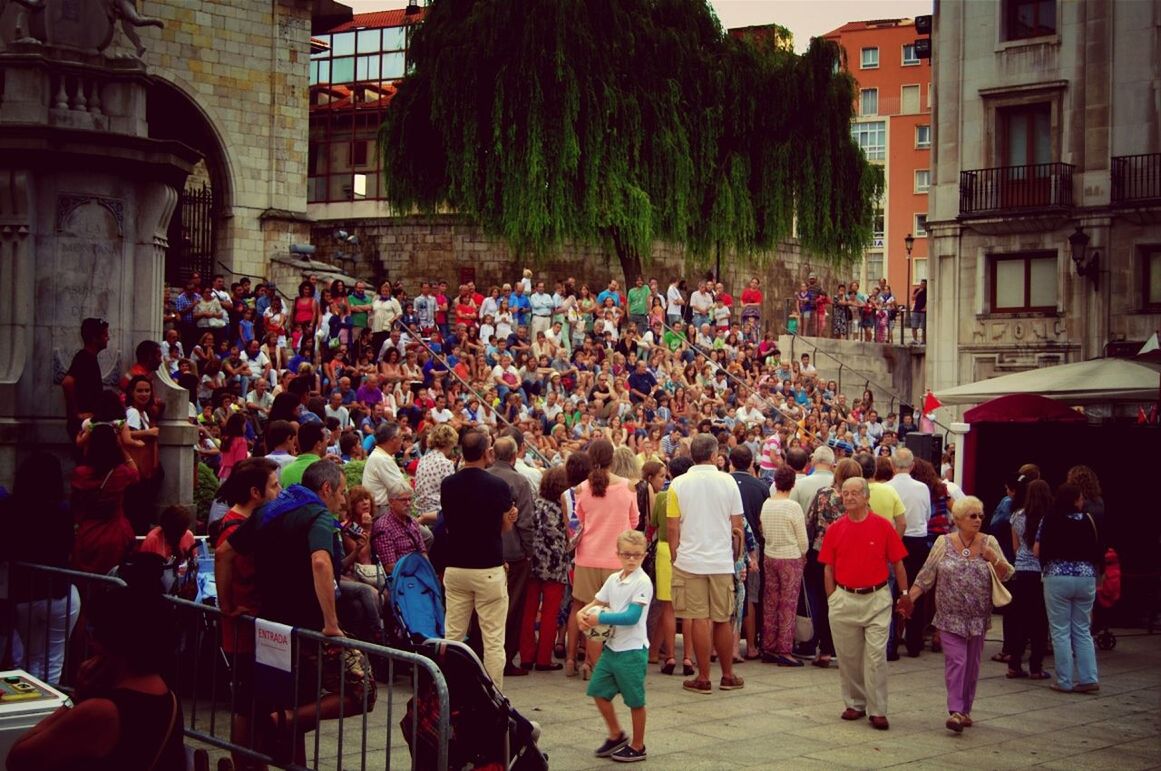 building exterior, large group of people, architecture, person, built structure, men, lifestyles, street, walking, city, crowd, leisure activity, city life, mixed age range, market, building, outdoors, day, residential structure