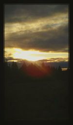 Silhouette of landscape against cloudy sky