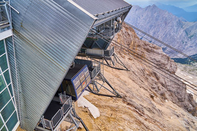 High angle view of crane by building against sky