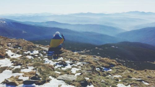 Man on snowcapped mountains against sky