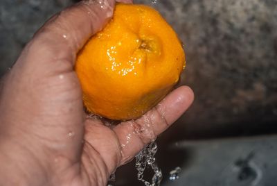 Close-up of hand washing orange