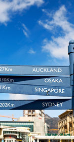 Low angle view of information sign against blue sky