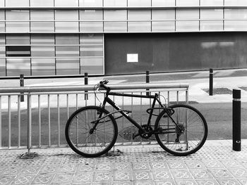 Bicycle parked on footpath against building
