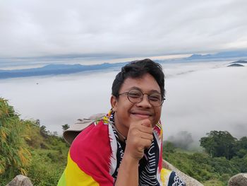 Portrait of smiling young man against sky