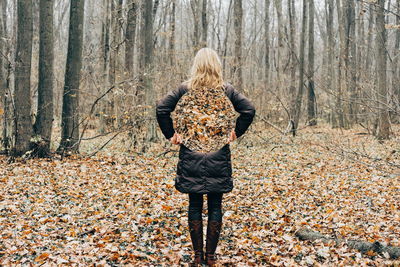 Woman standing on tree trunk during autumn