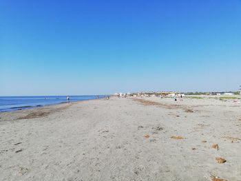 Scenic view of beach against clear blue sky