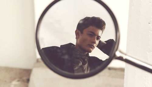 Reflection of man in side-view mirror