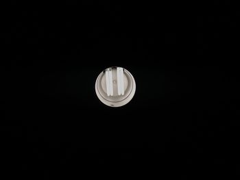 Low angle view of illuminated light bulb against black background