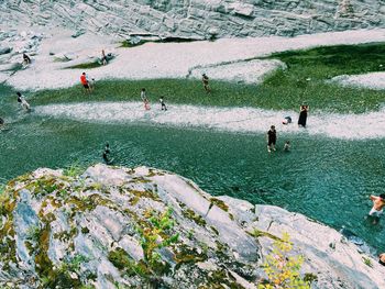 High angle view of people at river by rock formations