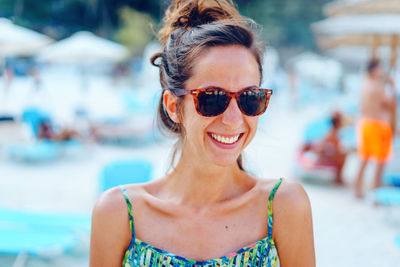 Portrait of smiling woman wearing sunglasses outdoors