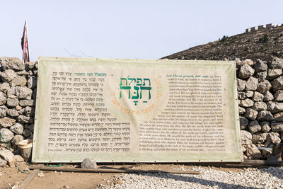 Close-up of sign board against clear sky