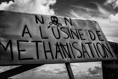 Low angle view of information sign against sky