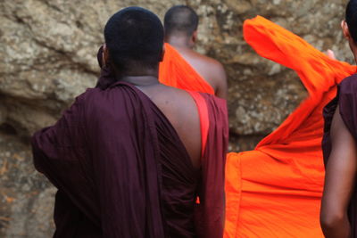 Rear view of monks praying in front of sigiriya rock