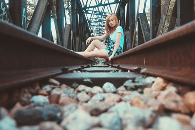 Young woman sitting on pebbles