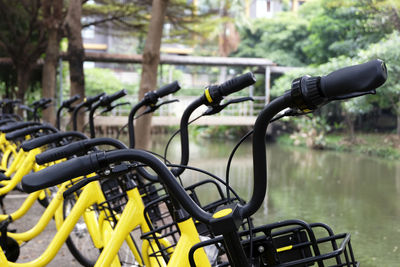 Close-up of yellow bicycles at lakeshore